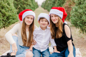 Children enjoying a festive holiday photo shoot at Dewberry Farm’s Christmas tree farm